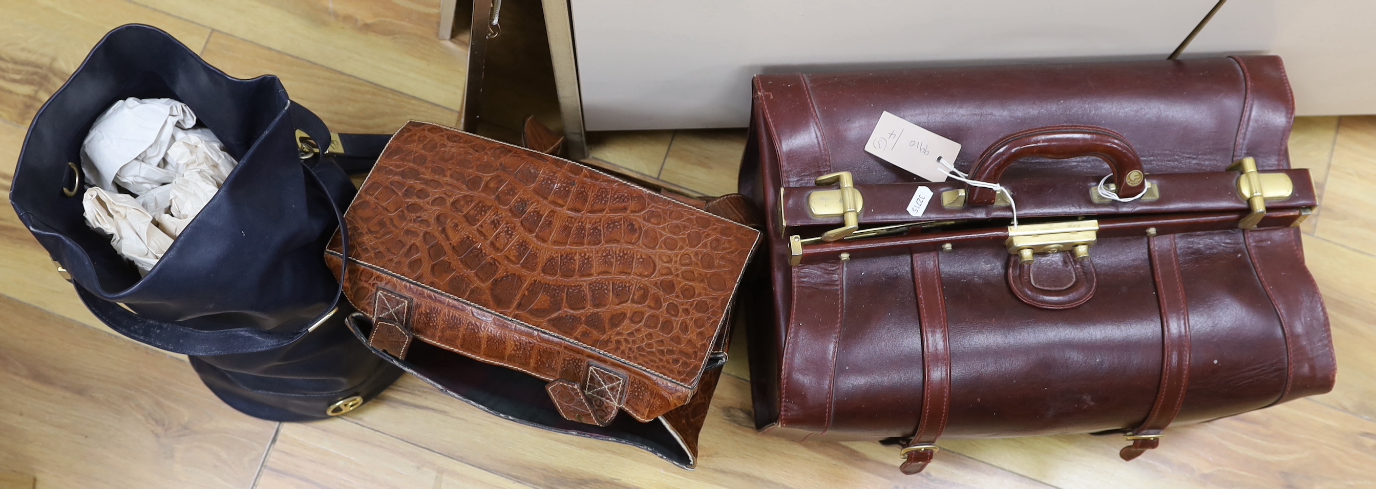 An oxblood leather Gladstone bag, a faux crocodile bag and one other